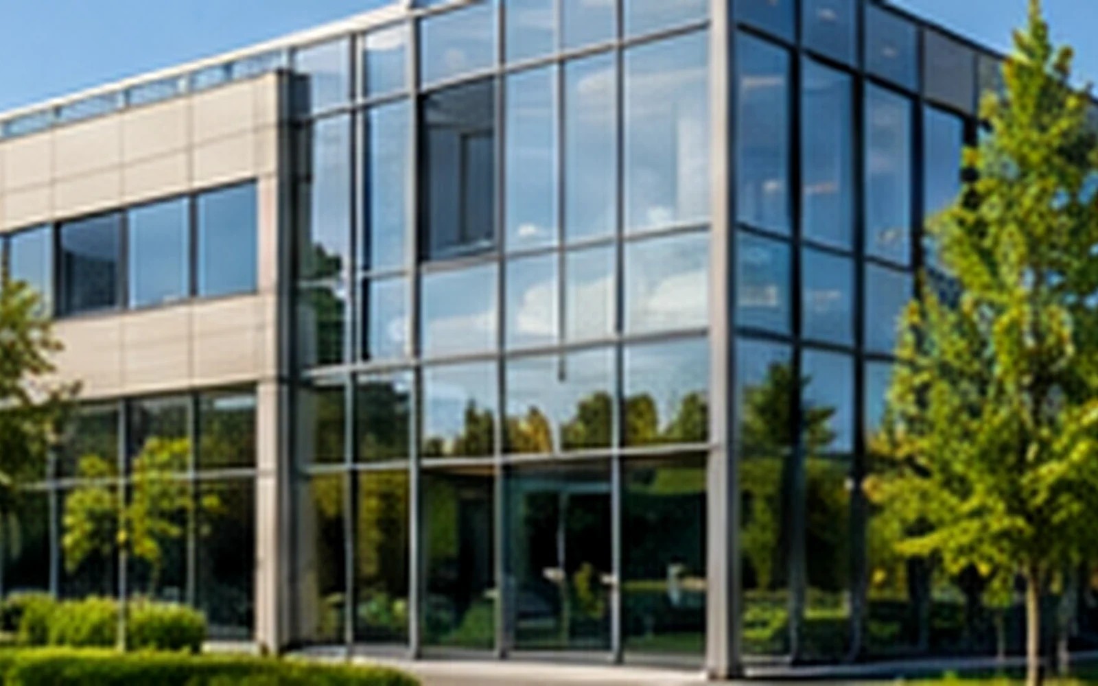 Modernes Bürogebäude mit Glasfassade und Grünflächen